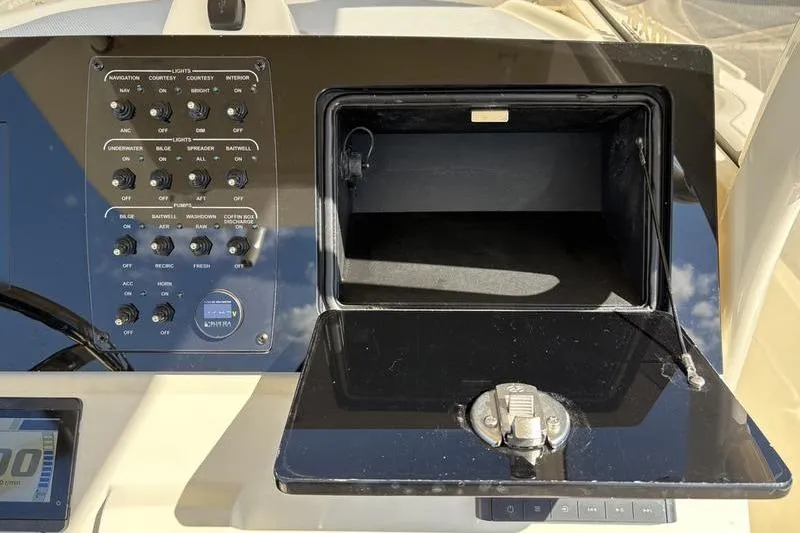 Slide: The Image of Control panel and storage compartment of 2026 Scout 240 XSF boat. - 22