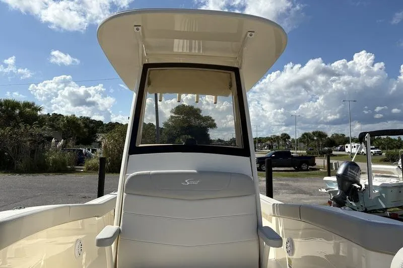 Slide: The Image of 2026 Scout 240 XSF boat with T-top, parked outdoors under a cloudy sky. - 28