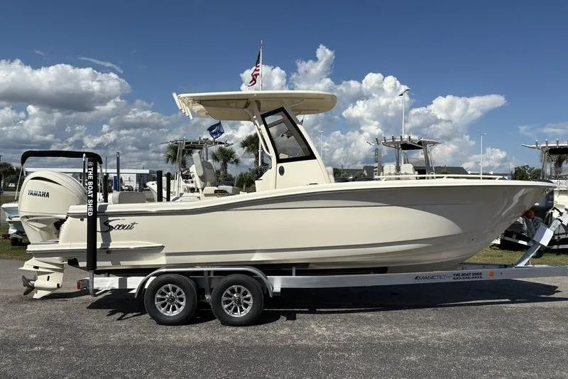 Slide: The Image of 2026 Scout 240 XSF boat on trailer, side view, under clear blue sky. - 4