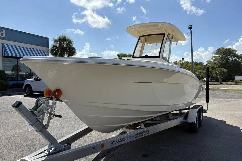 Slide: The Image of 2026 Scout 240 XSF boat on trailer under clear blue sky. - 7