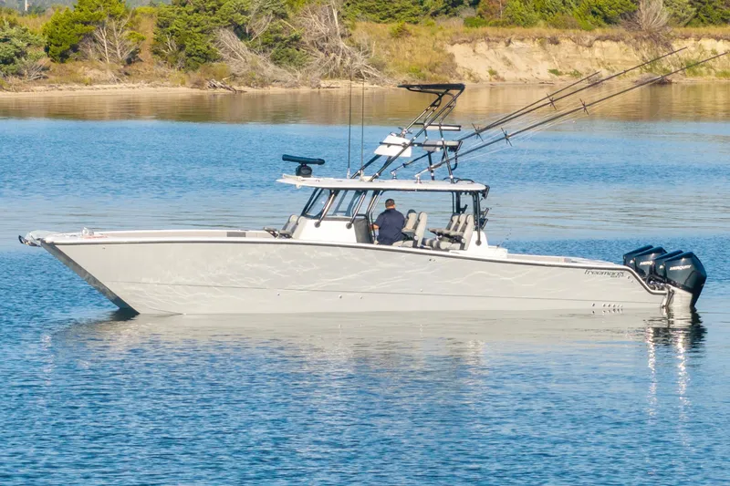 Slide: The Image of 2022 Freeman 42 LR boat on calm water with fishing rods and outboard motors. - 10