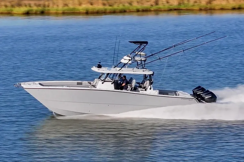 Slide: The Image of 2022 Freeman 42 LR boat cruising on a calm lake with fishing rods. - 13