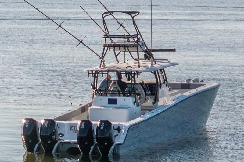 Slide: The Image of 2022 Freeman 42 LR boat with multiple outboard motors on calm water. - 6