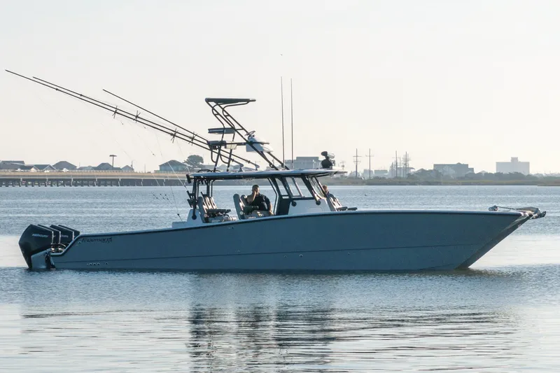 Slide: The Image of 2022 Freeman 42 LR boat on calm water, equipped with multiple fishing rods. - 9