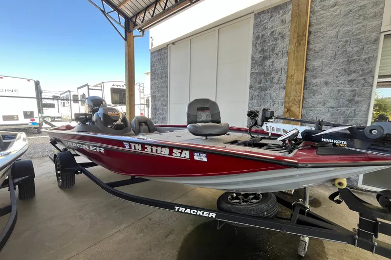 Slide: The Image of 2021 Bass Tracker Pro Team 195 TXW TE boat in showroom, red exterior, on trailer. - 23