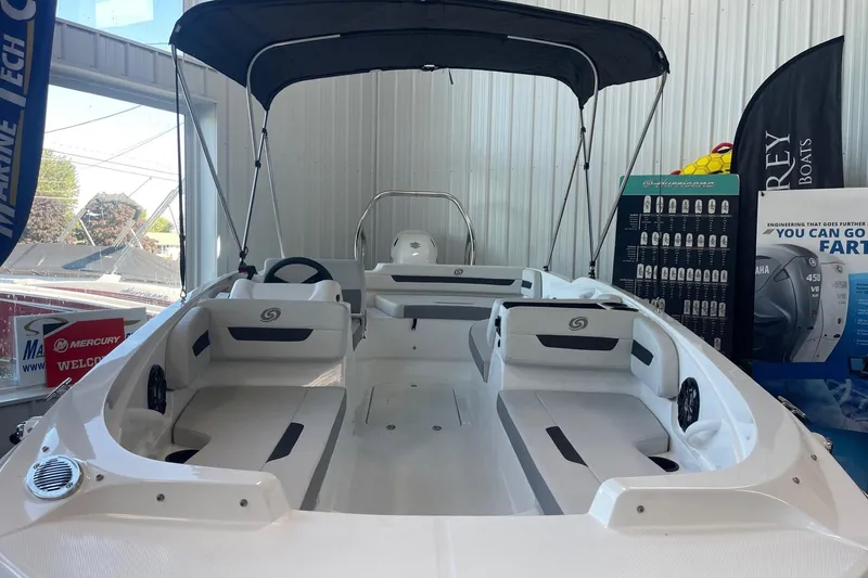 Slide: The Image of 2023 Hurricane SunDeck Sport 185 OB boat interior with seating and canopy in showroom. - 1