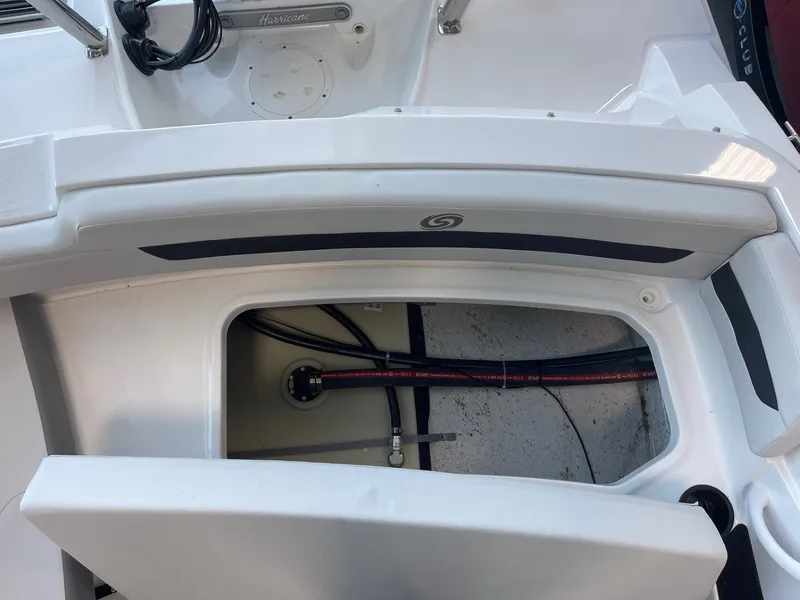 Slide: The Image of 2022 Hurricane SunDeck Sport 185 OB storage compartment with open hatch, showing interior details. - 18