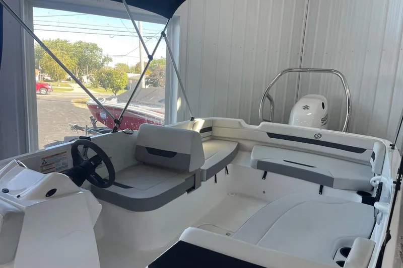 Slide: The Image of 2023 Hurricane SunDeck Sport 185 OB boat interior with seating and steering wheel in showroom. - 4