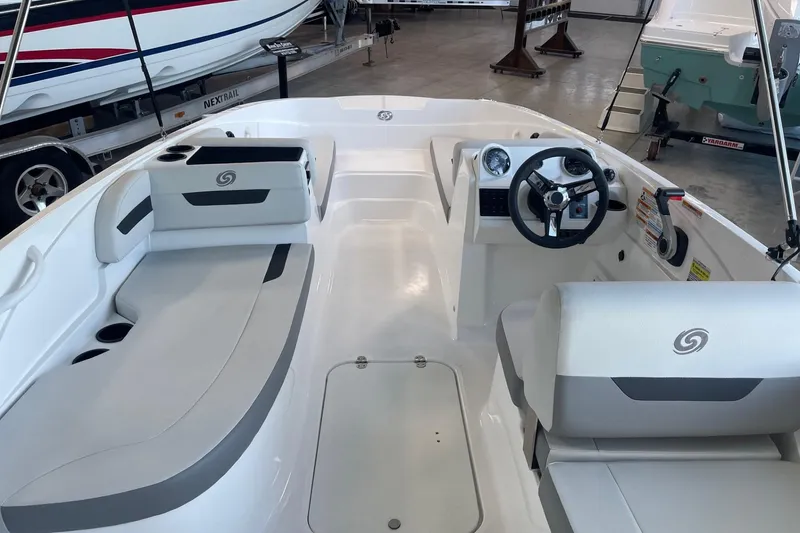 Slide: The Image of 2023 Hurricane SunDeck Sport 185 OB interior with seating and steering wheel in showroom. - 5