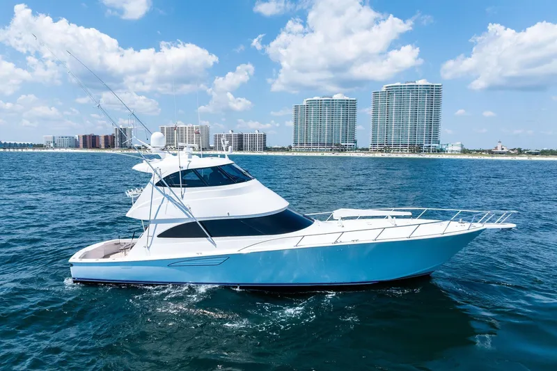 The Image of 2017 Viking 62 Enclosed Bridge yacht cruising near coastal skyline. - 0