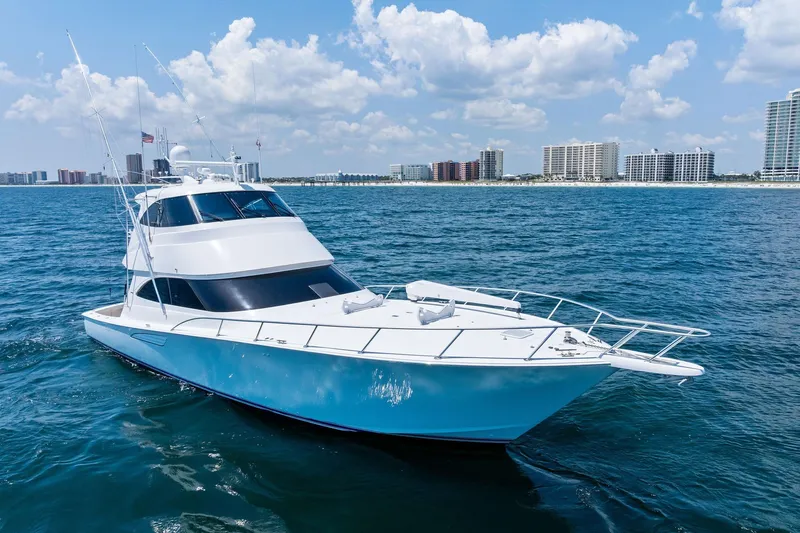 Slide: The Image of 2017 Viking 62 Enclosed Bridge yacht cruising on ocean near city skyline. - 1