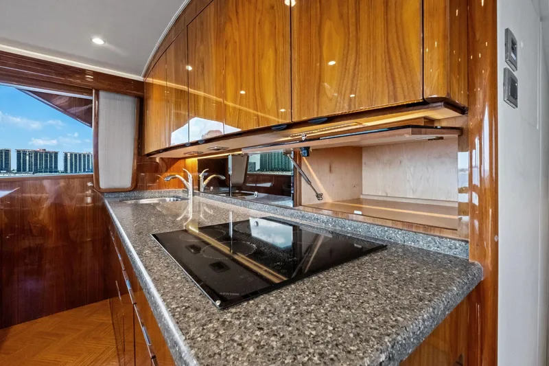 Slide: The Image of Luxurious kitchen interior of 2017 Viking 62 Enclosed Bridge yacht with sleek wood cabinetry. - 29