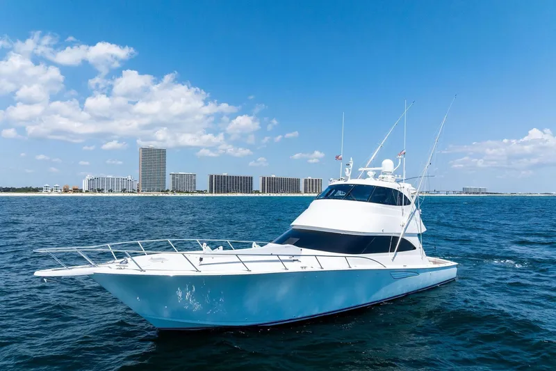 Slide: The Image of 2017 Viking 62 Enclosed Bridge yacht on open water with city skyline backdrop. - 3