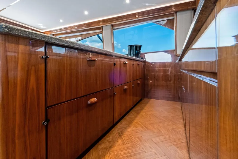 Slide: The Image of Luxurious interior of 2017 Viking 62 Enclosed Bridge yacht with polished wood cabinetry. - 30