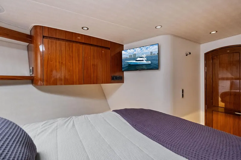 Slide: The Image of Luxurious bedroom interior of 2017 Viking 62 Enclosed Bridge yacht with TV and wooden cabinetry. - 41