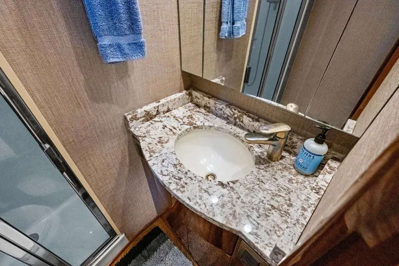 Slide: The Image of Luxurious bathroom in 2017 Viking 62 Enclosed Bridge yacht with granite countertop and modern fixtures. - 42