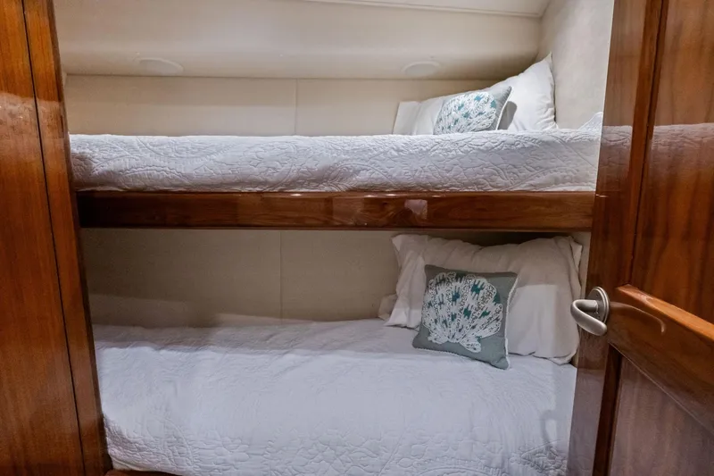 Slide: The Image of Bunk beds in 2017 Viking 62 Enclosed Bridge yacht cabin with white bedding and decorative pillows. - 51