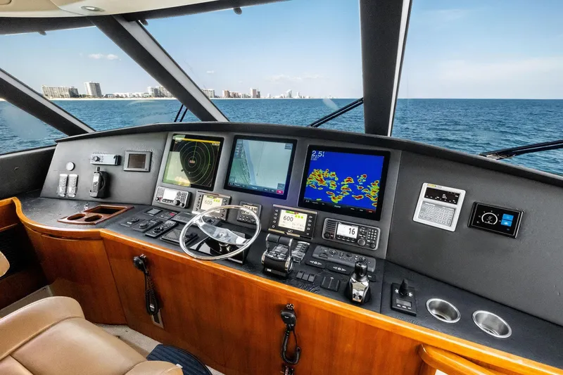 Slide: The Image of 2017 Viking 62 Enclosed Bridge helm with advanced navigation systems and ocean view. - 56