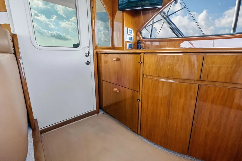 Slide: The Image of Interior of 2017 Viking 62 Enclosed Bridge with wooden cabinetry and door. - 60