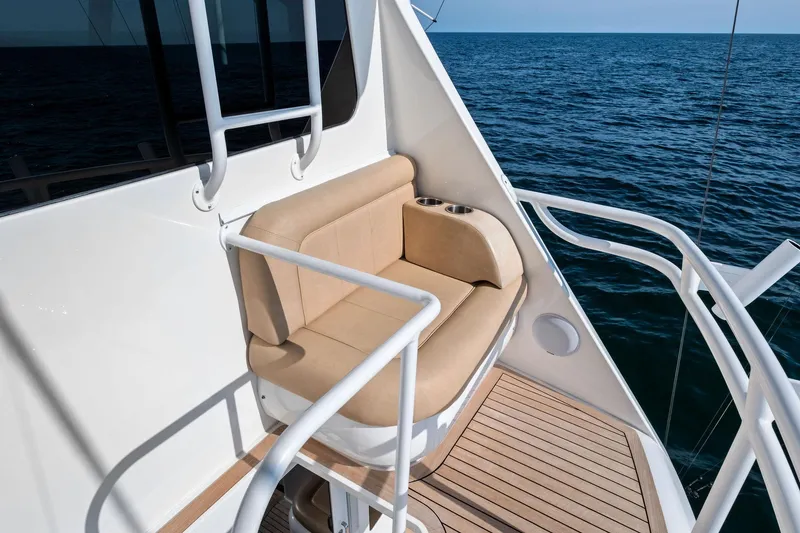 Slide: The Image of 2017 Viking 62 Enclosed Bridge yacht with beige seating, ocean view. - 63