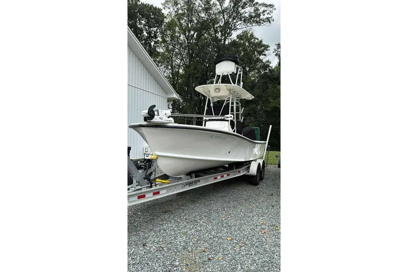 Slide: The Image of 2014 Privateer ROAMER II boat on trailer near a white building. - 3