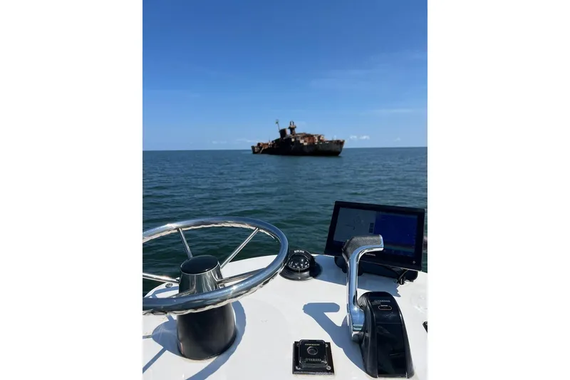 Slide: The Image of Privateer ROAMER II 2014 boat steering towards distant shipwreck on open sea. - 4