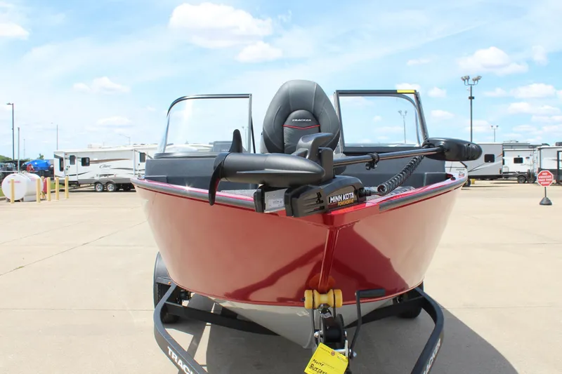 Slide: The Image of 2026 Tracker Super Guide V-16 SC boat with Minn Kota motor in parking lot. - 2