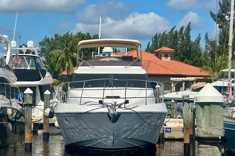 Slide: The Image of 1999 Azimut 58 yacht docked at marina, surrounded by other boats, under a clear blue sky. - 10