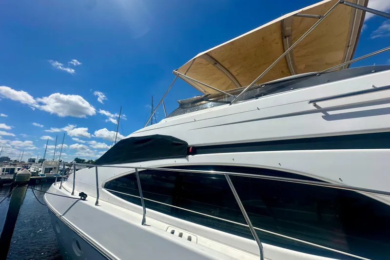 Slide: The Image of 1999 Azimut 58 yacht docked under a clear blue sky. - 13