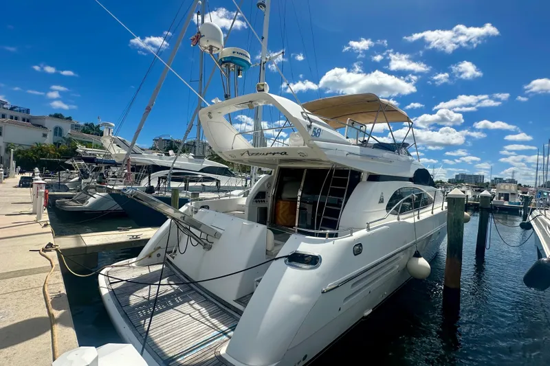 Slide: The Image of 1999 Azimut 58 yacht docked at marina under clear blue sky. - 14