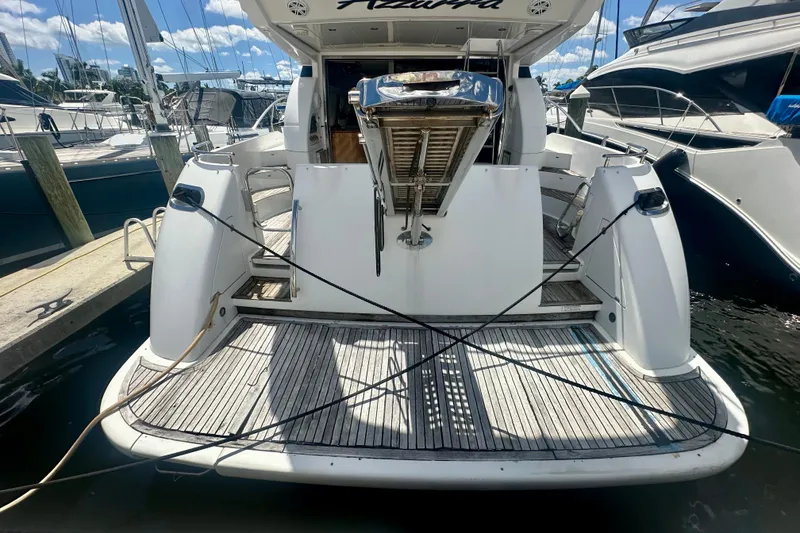 Slide: The Image of 1999 Azimut 58 yacht docked, rear view showing spacious deck and mooring lines. - 15