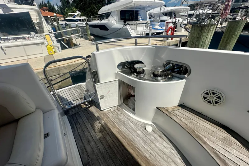 Slide: The Image of 1999 Azimut 58 yacht deck with winches and wooden flooring at a marina. - 26
