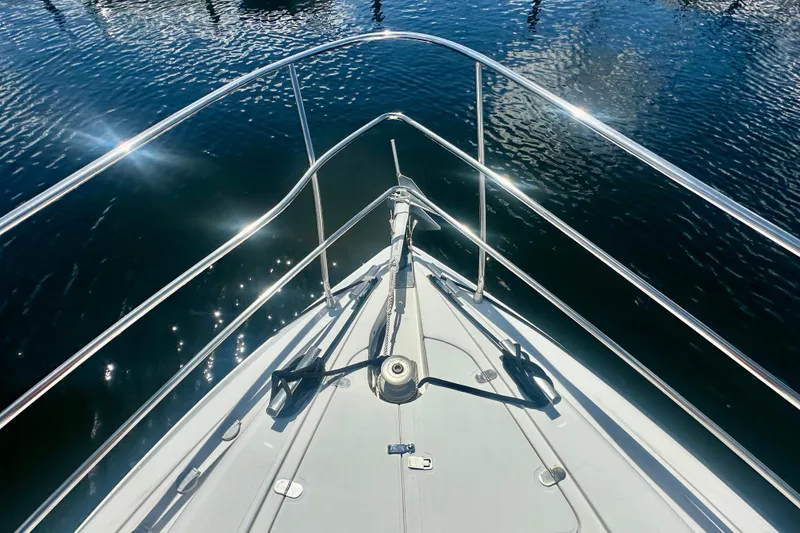 Slide: The Image of Bow view of 1999 Azimut 58 yacht with gleaming railings and calm water reflections. - 29