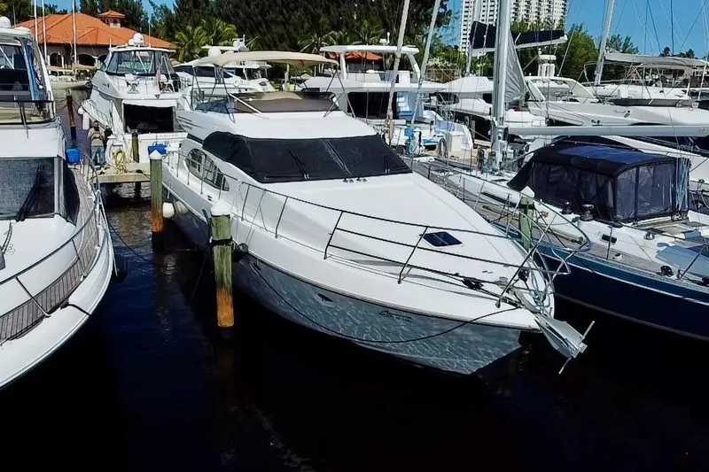 Slide: The Image of 1999 Azimut 58 yacht docked at a marina, surrounded by other boats. - 3