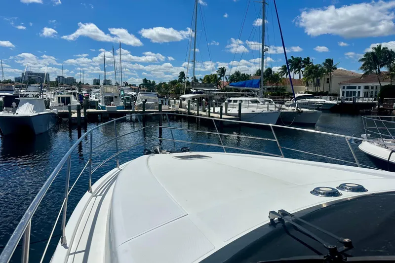 Slide: The Image of 1999 Azimut 58 yacht docked in a sunny marina with clear blue skies. - 30