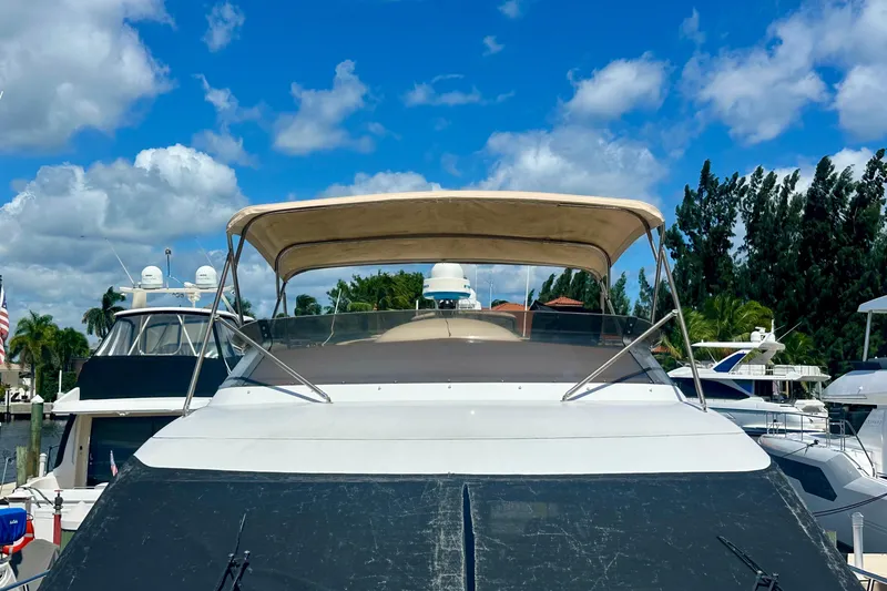 Slide: The Image of 1999 Azimut 58 yacht docked under a clear blue sky. - 32