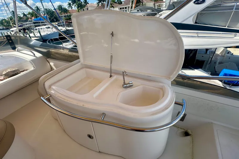 Slide: The Image of 1999 Azimut 58 yacht sink area with open lid, marina background. - 46