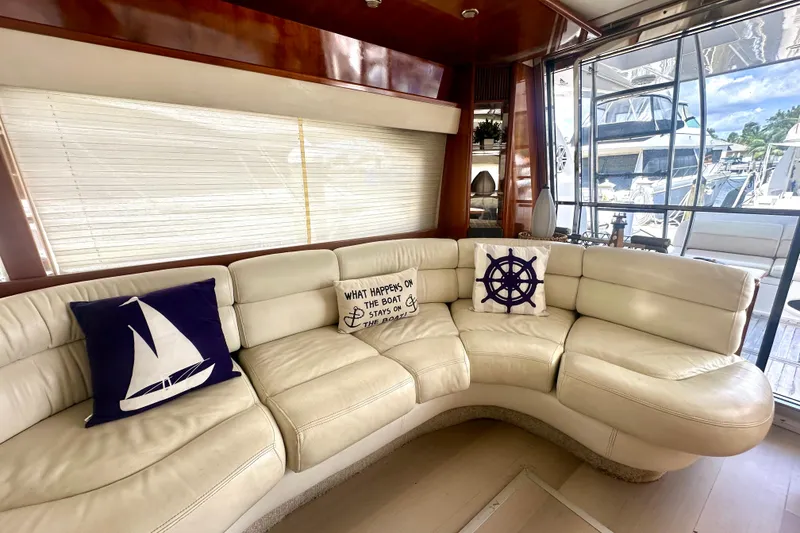 Slide: The Image of Luxurious interior of 1999 Azimut 58 yacht with cream leather seating and nautical-themed pillows. - 56