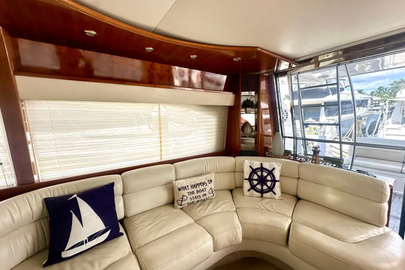 Slide: The Image of Luxurious interior of a 1999 Azimut 58 yacht with cream leather seating and nautical-themed pillows. - 58