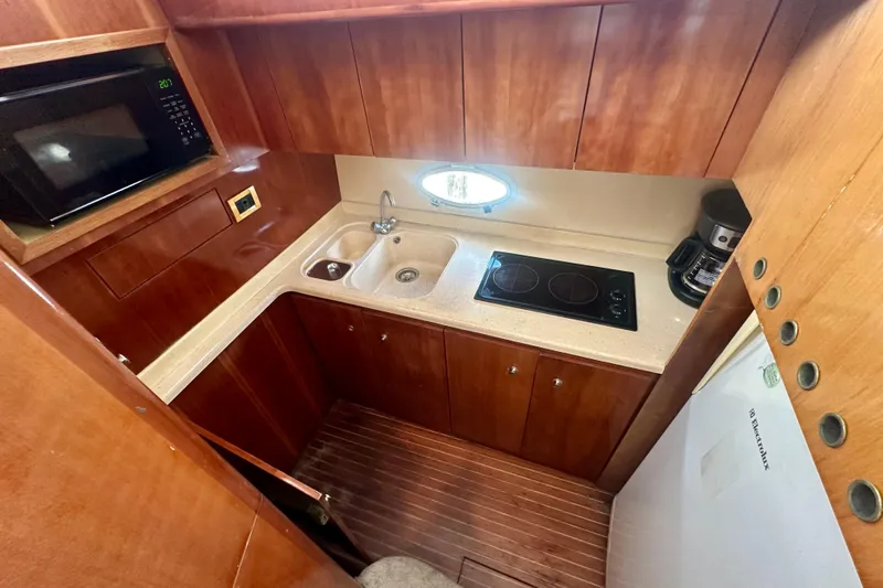 Slide: The Image of Compact kitchen in a 1999 Azimut 58 yacht with stove, sink, and microwave. - 65