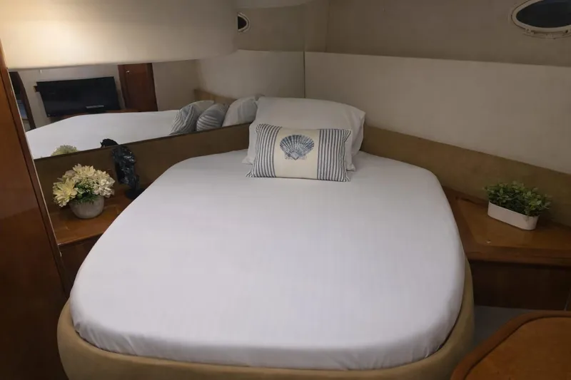 Slide: The Image of Cozy bedroom interior of 1999 Azimut 58 yacht with elegant decor and porthole windows. - 74