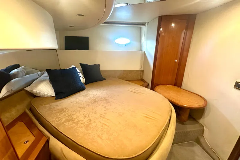 Slide: The Image of Luxurious cabin interior of a 1999 Azimut 58 yacht with cozy bedding and wooden accents. - 79