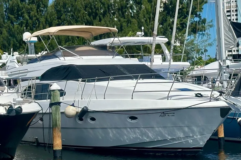 Slide: The Image of 1999 Azimut 58 yacht docked at marina, featuring sleek design and spacious deck. - 8