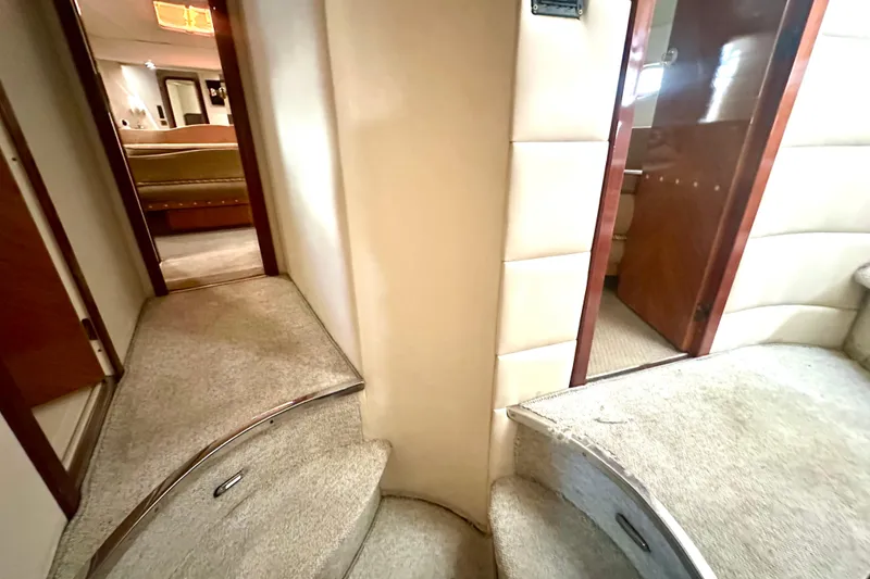 Slide: The Image of Interior of 1999 Azimut 58 yacht, featuring carpeted stairs and luxurious cabin access. - 82