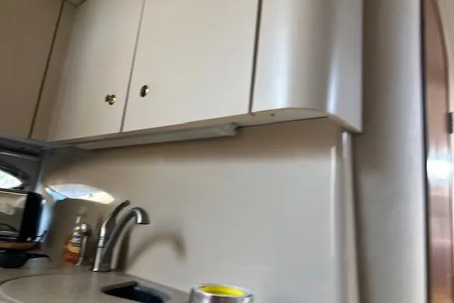 Slide: The Image of Interior of 2000 Cruisers 3575 yacht, featuring a compact kitchen area. - 13