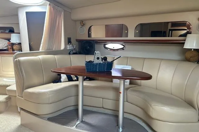 Slide: The Image of Luxurious interior of 2000 Cruisers 3575 yacht with beige seating and wooden table. - 14