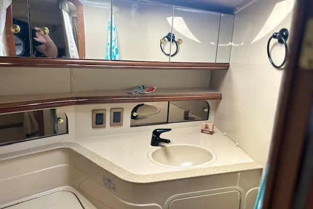 Slide: The Image of 2000 Cruisers 3575 yacht bathroom with sink, mirrors, and storage cabinets. - 18