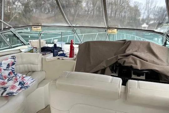 Slide: The Image of 2000 Cruisers 3575 yacht interior with white seating, covered dashboard, and scenic view. - 4