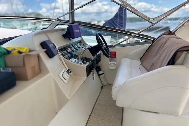 Slide: The Image of 2000 Cruisers 3575 boat cockpit with steering wheel, gauges, and white seating. - 5