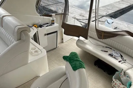 Slide: The Image of Interior of a 2000 Cruisers 3575 yacht with white seating and dock view. - 8